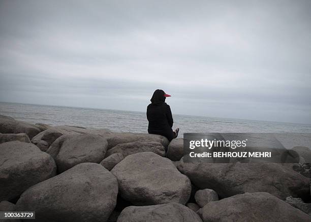 An Iranian woman sits by the water in the Caspian Sea city of Tonekabon, 250 kms north of the capital Tehran, on May 21, 2010. The Caspian Sea is the...