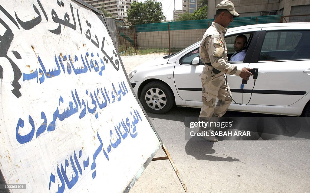 An Iraqi soldier inspects a car during a