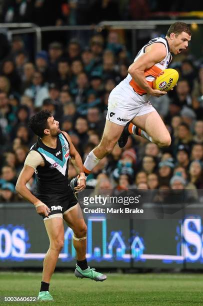 Heath Shaw of the Giants takes a huge leaping mark over Lindsay Thomas of Port Adelaide during the round 18 AFL match between the Port Adelaide Power...