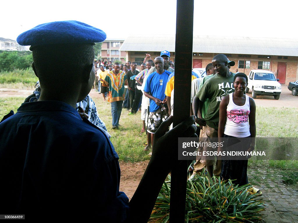 A Burundian police officer watches voter