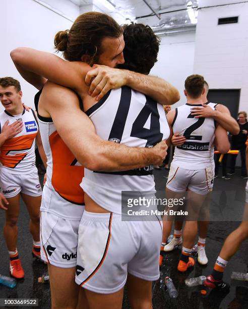 Phil Davis and Tim Taranto of the Giants hug afte the team song during the round 18 AFL match between the Port Adelaide Power and the Greater Western...