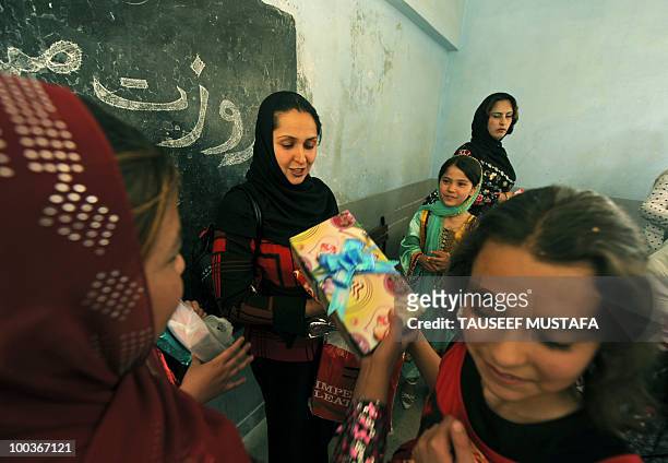 An Afghan teacher receives gifts from her schoolchildren at a school in central Kabul on May 24 on World Teacher's Day. Afghanistan has been...