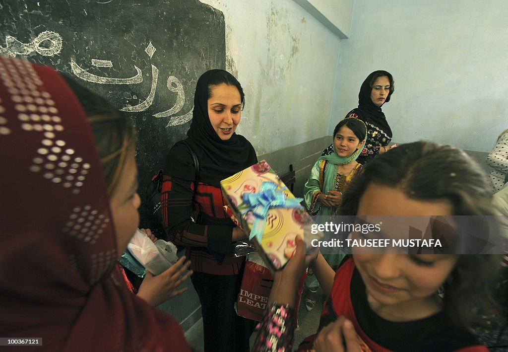 An Afghan teacher receives gifts from he