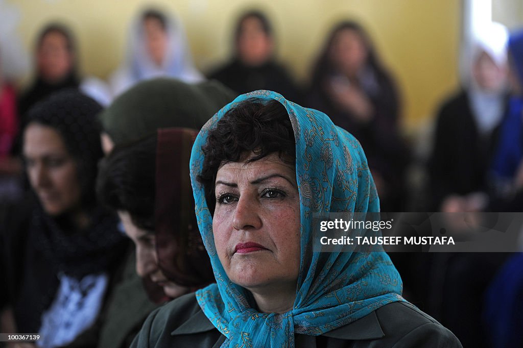 An Afghan school teacher looks on during