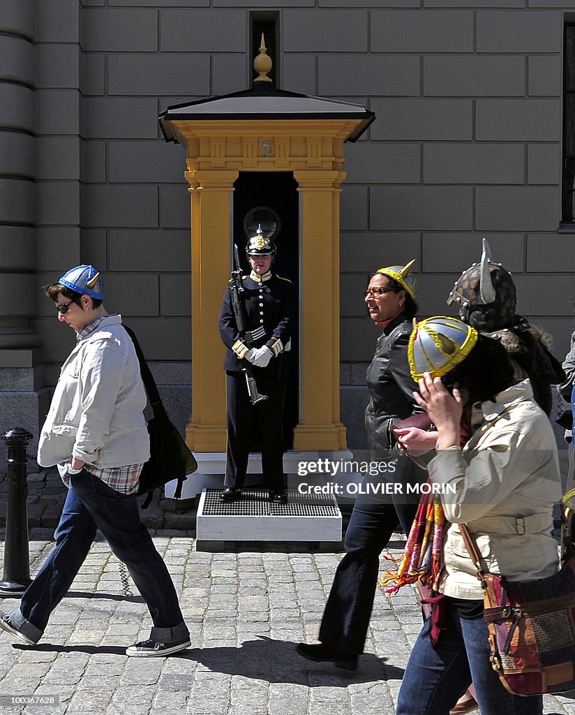 Tourists wearing Viking helmets pass by