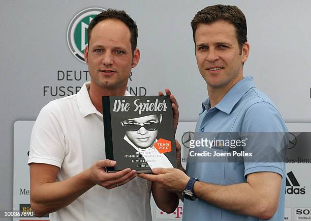 Team manager Oliver Bierhoff of Germany and Stephan Braun of DFB are pictured with the illustrated book "Die Spieler" during a press conference at...