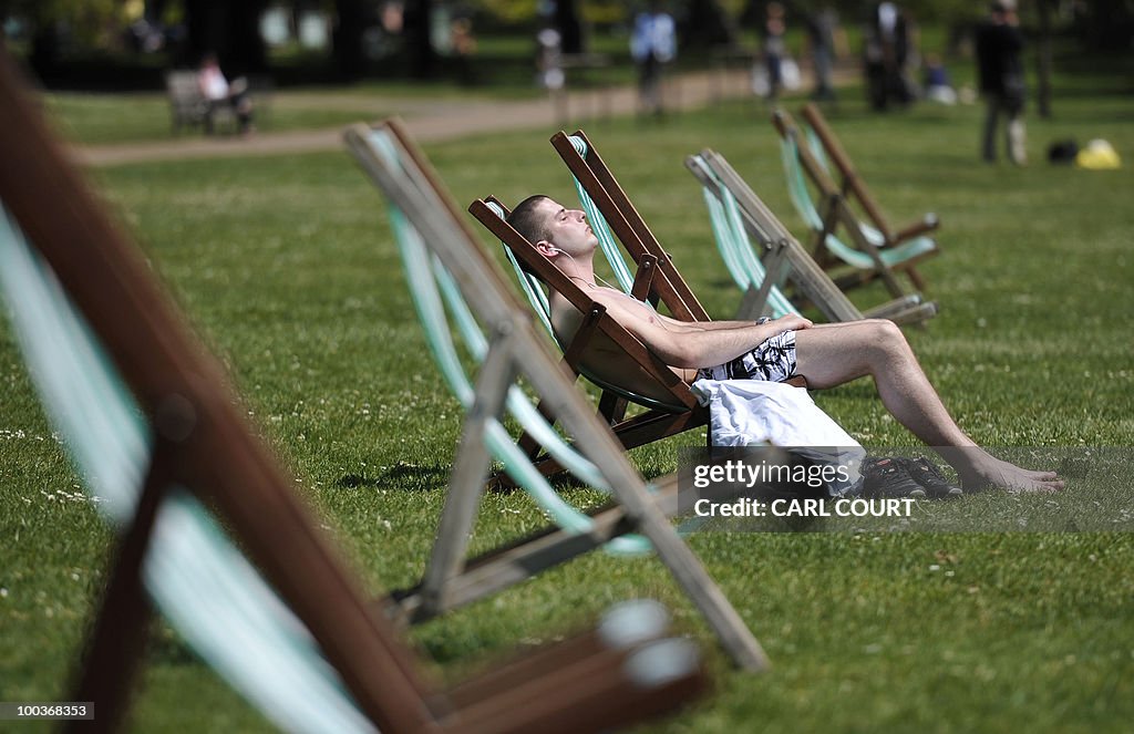 A man sunbathes in St James' Park in Lon