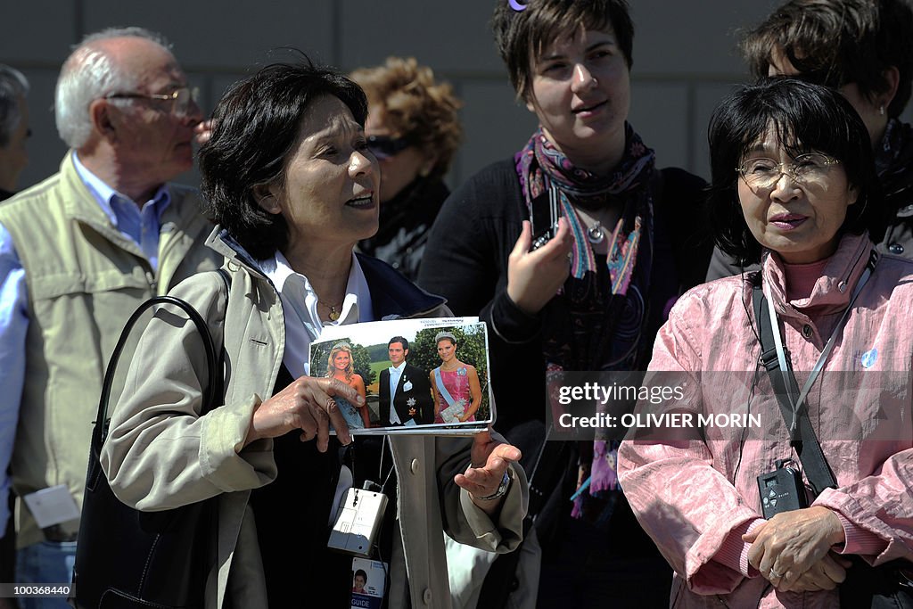 A tourist guide holds a picture of the c