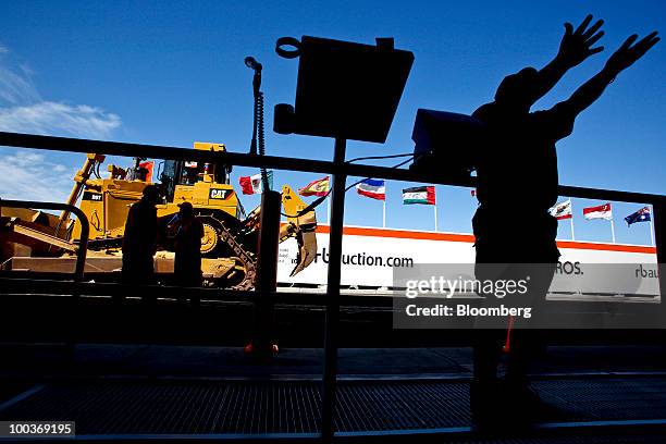 Ringman takes bids in for a Caterpillar Inc. Track loader during a Ritchie Bros. Auctioneers Inc. Industrial equipment auction in Dunnigan,...