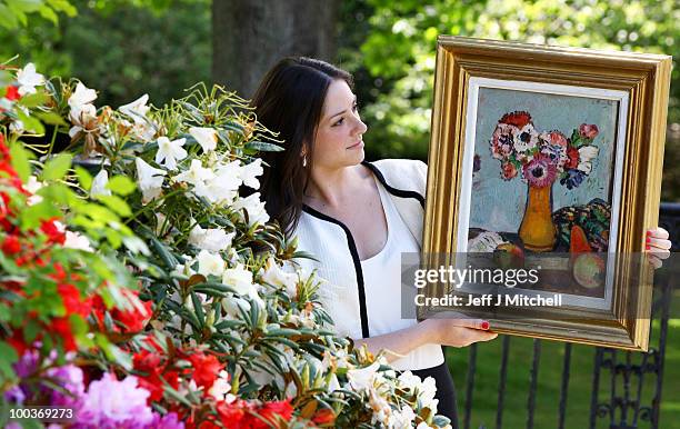 Caitlin Cruckshanks from Lyon & Turnbull holds a still life by Scottish Colourist George Leslie Hunter called Still Life with Fruit and Anemones at...