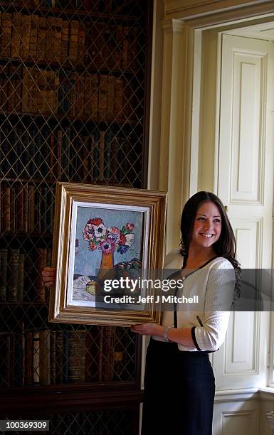 Caitlin Cruckshanks from Lyon & Turnbull holds a still life by Scottish Colourist George Leslie Hunter called Still Life with Fruit and Anemones at...