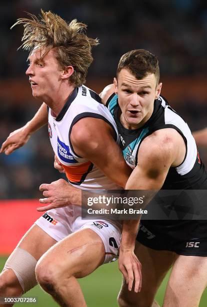 Lachie Whitfield of the Giants tackled by Robbie Gray of Port Adelaide during the round 18 AFL match between the Port Adelaide Power and the Greater...