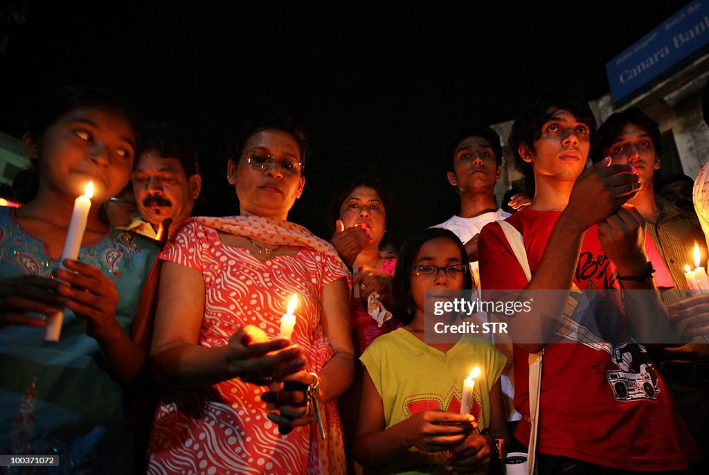 Mourners hold candles during a vigil for