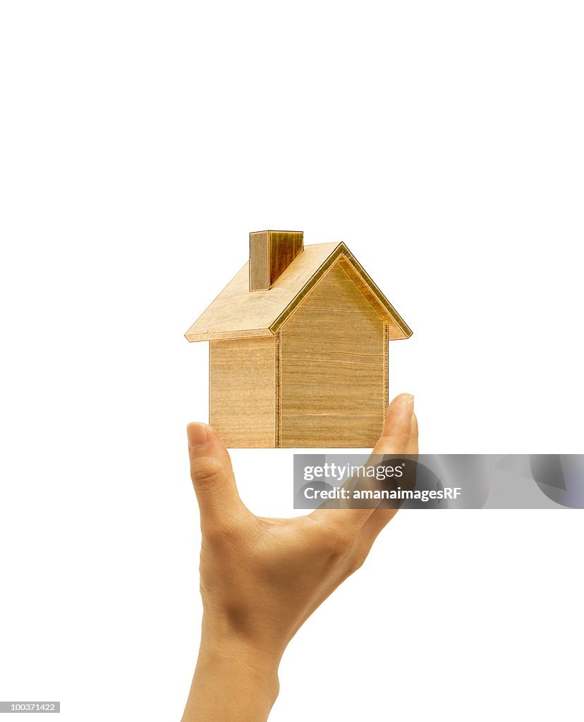 Hand holding wooden house, white background