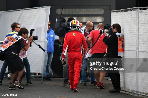 Sebastian Vettel of Germany and Ferrari walks back into the paddock after crashing during the Formula One Grand Prix of Germany at Hockenheimring on...