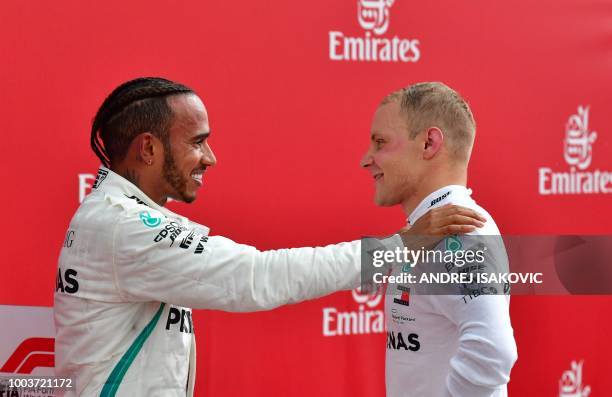 Winner Mercedes' British driver Lewis Hamilton talks with second placed Mercedes' Finnish driver Valtteri Bottas after the German Formula One Grand...