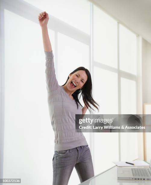 businesswoman cheering in office - happy surprise stock pictures, royalty-free photos & images