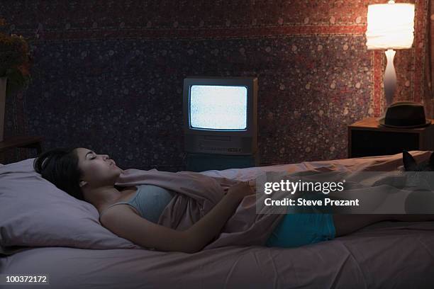 hispanic woman sleeping with television on - woman sleep bedroom foto e immagini stock