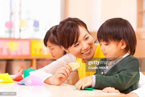 nursery teacher talking to children - origami instructions stock pictures, royalty-free photos & images