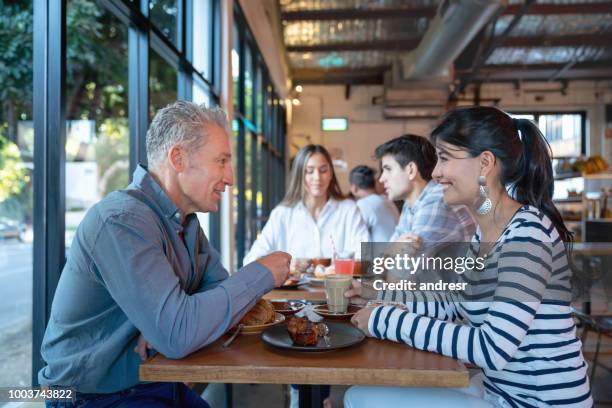 happy group of people eating together at a restaurant - australian cafe stock pictures, royalty-free photos & images