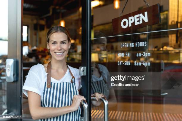 happy business owner opening the door at a cafe - retail store opening stock pictures, royalty-free photos & images