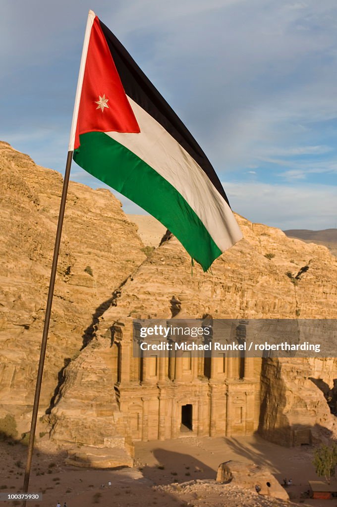 The Jordanian flag in front of Al Deir (the Monastery) at sunset, Petra, UNESCO World Heritage Site, Jordan, Middle East