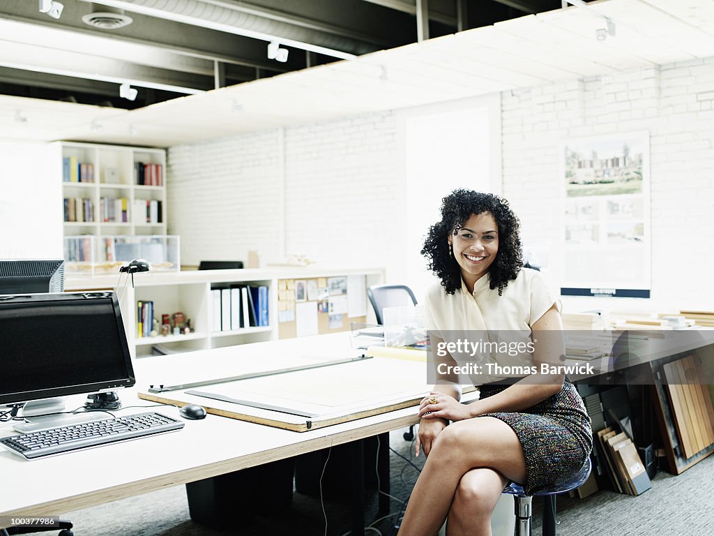 Young female architect sitting at desk in office