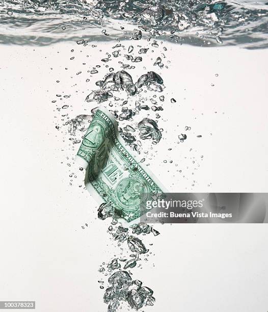 dollar note under water - money laundering fotografías e imágenes de stock