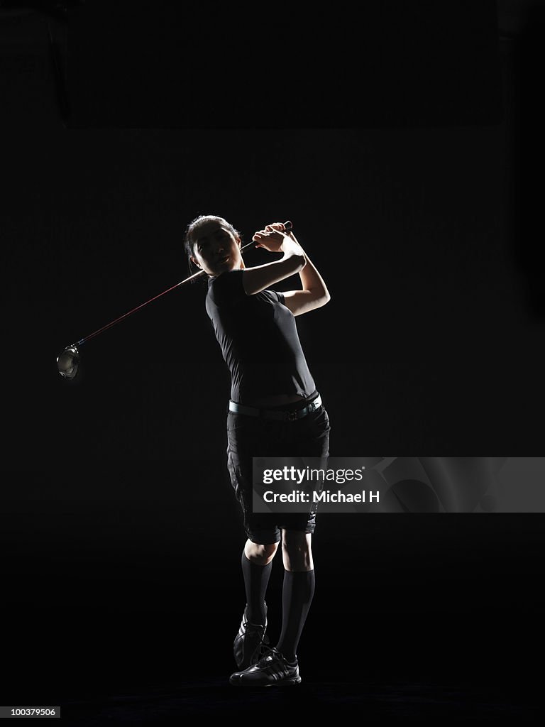  The lady golfer swings the driver of golf