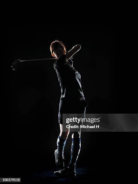 lady golfer who finished swinging driver of golf - portrait studio shot stock pictures, royalty-free photos & images