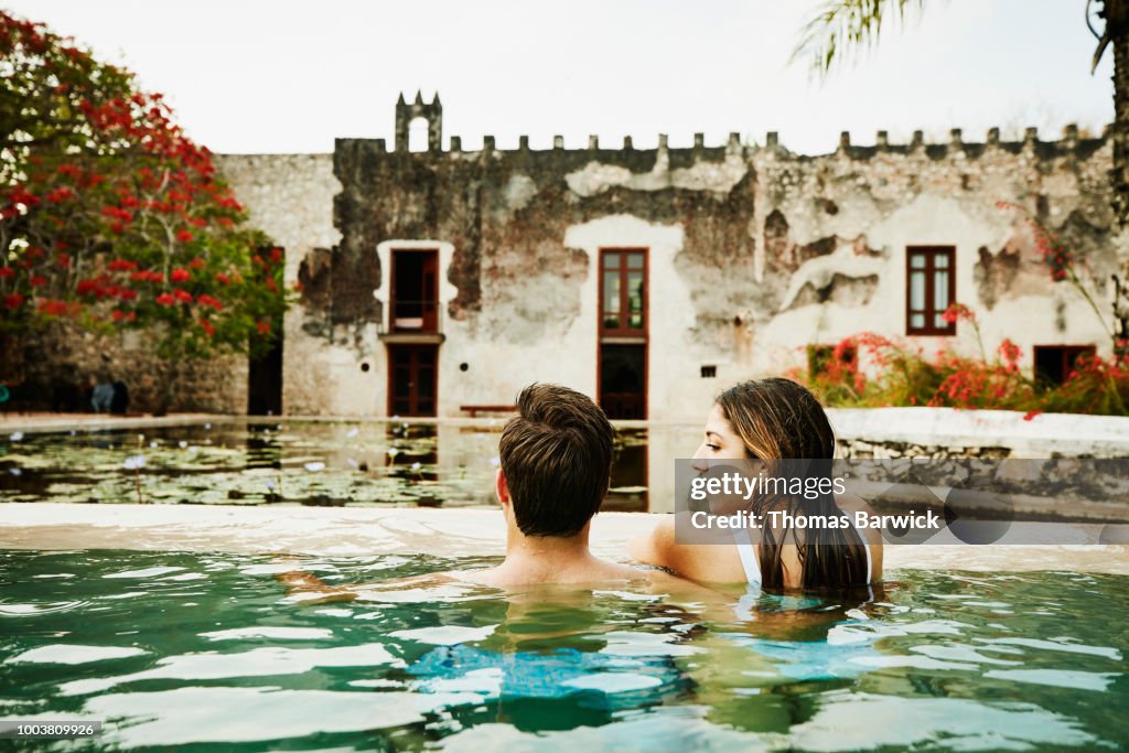 Couple relaxing together in pool at tropical luxury resort