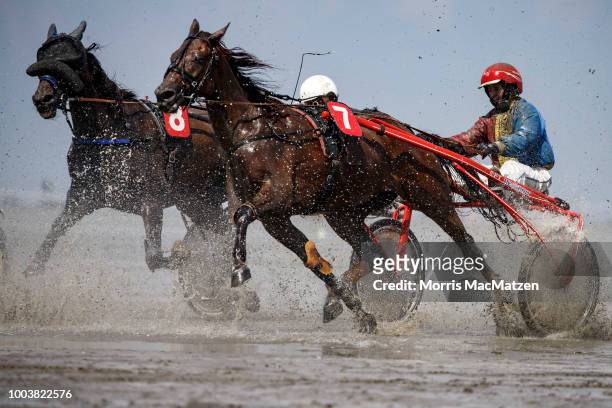 Horse and buggy teams compete in the annual horse buggy races on the mudflats at Duhnen on July 22, 2018 in Cuxhaven, Germany. The races, which in...