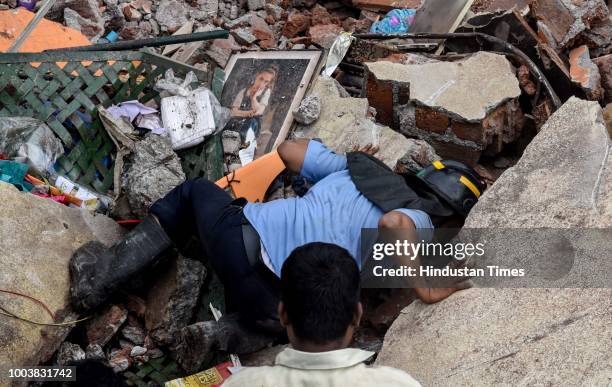 Fire brigade officers and locals try to rescue animals after rescuing 8 people were trapped as a wall of a two-storey residential building collapsed...