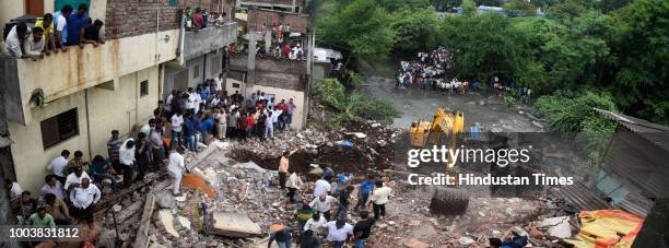 Fire brigade officers and locals try to rescue animals after rescuing 8 people were trapped as a wall of a two-storey residential building collapsed...