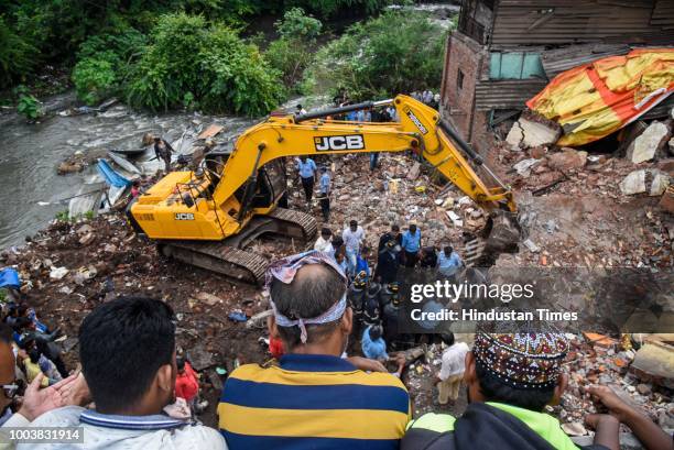 Fire brigade officers and locals try to rescue animals after rescuing 8 people were trapped as a wall of a two-storey residential building collapsed...