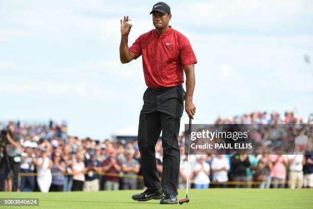 Golfer Tiger Woods acknowledges the applause after holing his putt on the 8th hole during his final round on day 4 of The 147th Open golf...