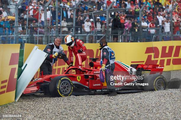 Sebastian Vettel of Germany and Ferrari climbs from the car after crashing during the Formula One Grand Prix of Germany at Hockenheimring on July 22,...