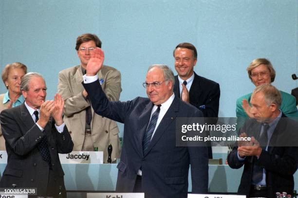 Former German chancellor Helmut Kohl receives felicitations from Karl Carstens after he was re-elected with the outgoing general secretary Heiner...