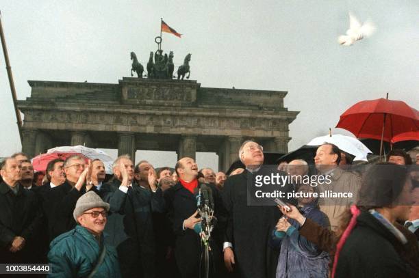 Former German chancellor Helmut Kohl can be seen with GDR prime minister Hans Modrow in front of the Brandenburg gate, letting doves of peace fly in...