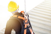 Industrial Worker with safety protective equipment loop and harness hanging at his back