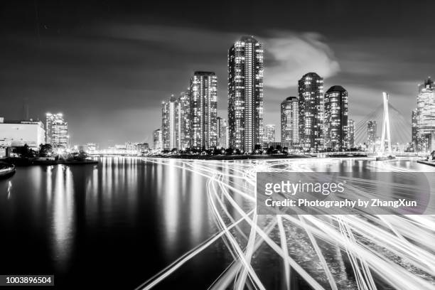 black&white image of tsukishima skyscrapers nightview with house boat light trails - tsukishima tokyo stock pictures, royalty-free photos & images