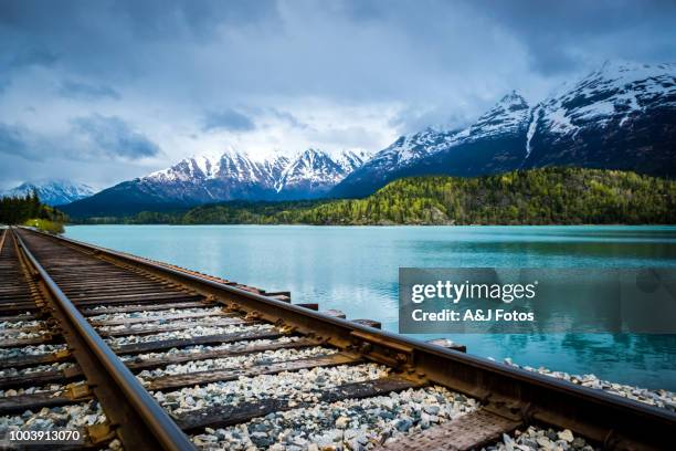 vía férrea con lago y cordillera - northern rail fotografías e imágenes de stock