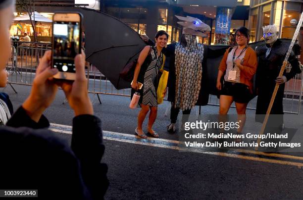 Fans pose for pictures in the Gaslamp District on Preview Night during the San Diego Comic-Con at the San Diego Convention Center in San Diego on...