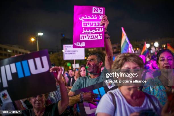Protester holds an anti-discrimination placard as he takes part in a demonstration against the passage of a law that expands eligibility for...