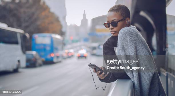 woman listening music downtown - shanghai calling stock pictures, royalty-free photos & images