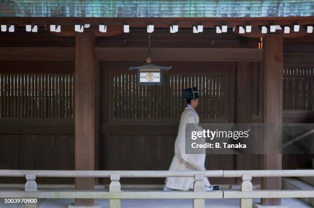 wooden cloister and shinto priest at sacred meiji shrine in tokyo, japan - meiji jingu shrine stock pictures, royalty-free photos & images