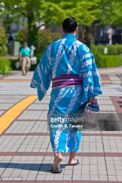 stylish young sumo wrestler arrives at ryogoku sumo hall in the old sumida district of tokyo, japan - wrestling arena stock pictures, royalty-free photos & images