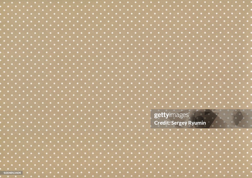 Polka dot on beige paper as an abstract background