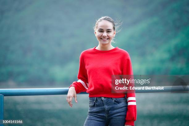 Model wears a red pullover, blue denim jeans , during Feeric Fashion Week 2018, on July 22, 2018 in Sibiu, Romania.