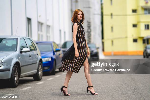 Dariana Cerciu wears a striped sleeveless dress with black lace, black heels shoes, during Feeric Fashion Week 2018, on July 22, 2018 in Sibiu,...